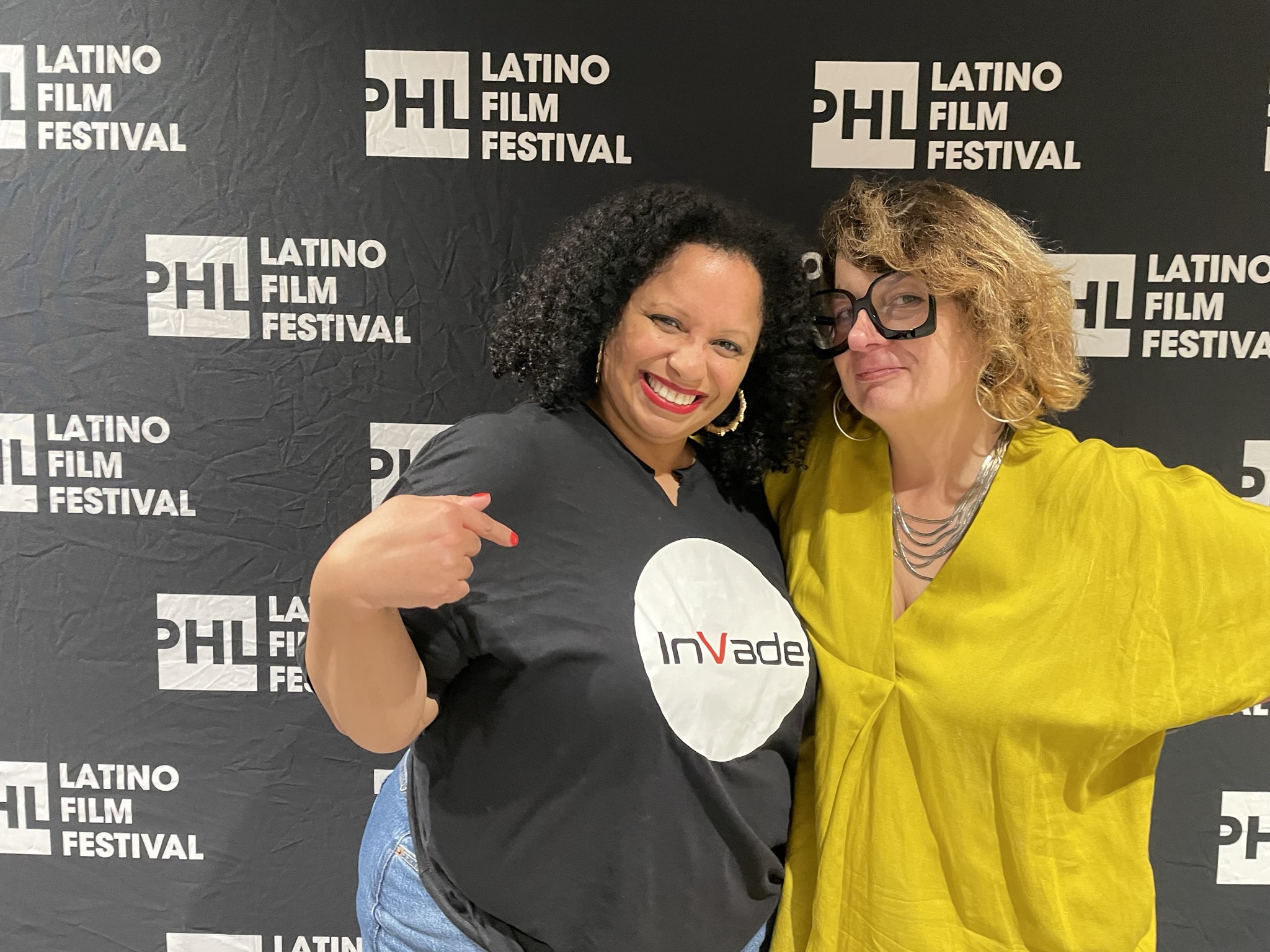 two people pose in front of a backdrop that reads: PHL Latino Film Festival