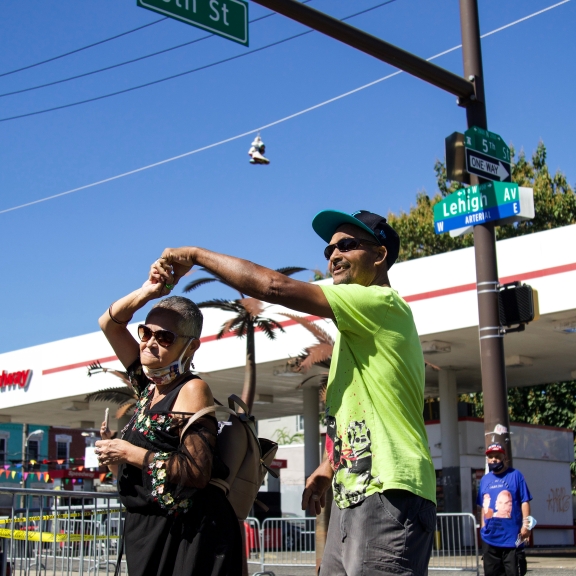 One person twirls another by the hand at the intersection of 5th Street and Lehigh Avenue
