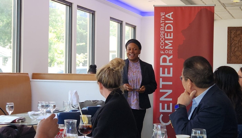 woman speaking publicly in front of a group of people