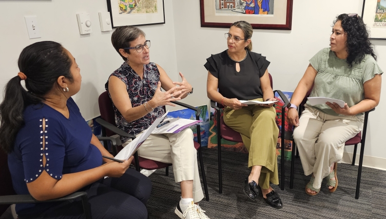 a group of women sit together in a corner having a conversation