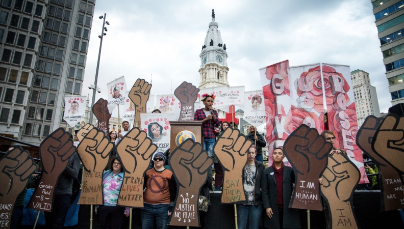 a rally in front of Philly's city hall with a group of people holding cut out signs of fists