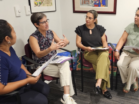 a group of women sit together in a corner having a conversation