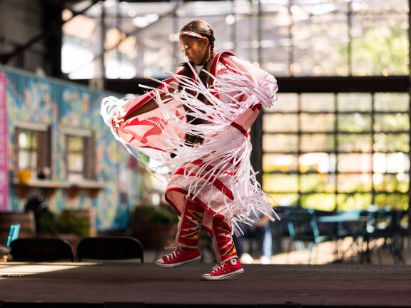 A little girl dances at a Powwow