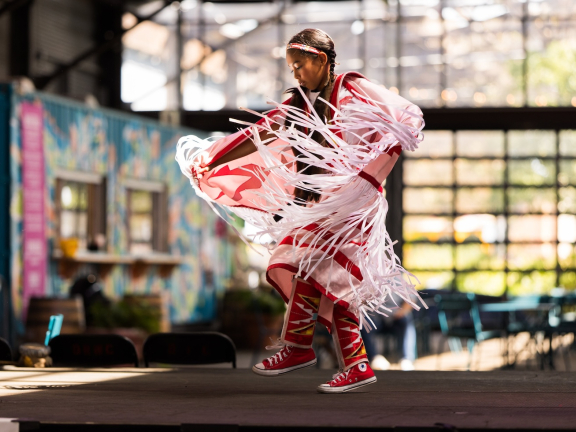 A little girl dances at a Powwow