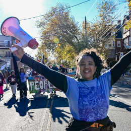 a person holding megaphone up in their hands while leading a parade